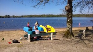 A lakeside setting with a bench and canoes near the water's edge.
