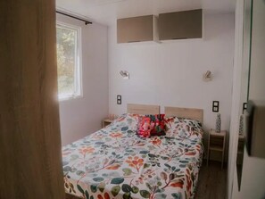 Una camera da letto con una coperta a fiori, due comodini e una finestra.