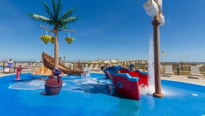 A water play area with a palm tree, a wooden boat, and a water fountain. - Phoenix V Vacation Rental Condominiums (Orange Beach)