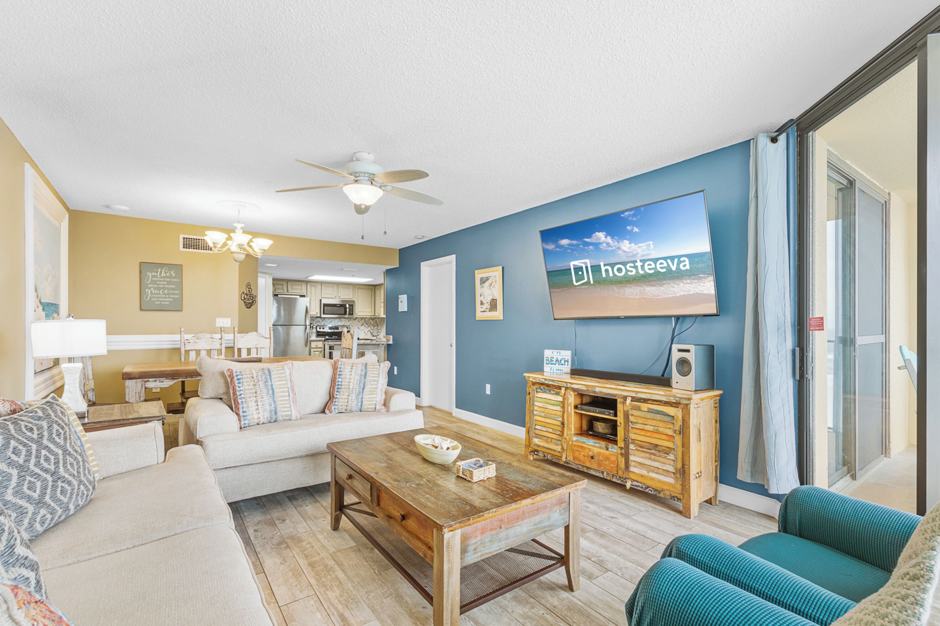 A living room with a sofa, coffee table, and a TV mounted on the wall.