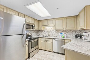 Condo Prestigio | Cocina privada | Refrigerador, microondas, horno y parrilla de estufa 