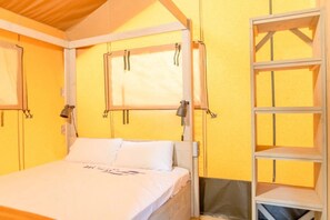 Ein Zimmer mit einem Bett, einem Fenster und einer eingebauten Regaleinheit.