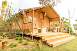 Eine Holzhütte mit überdachter Veranda, Sitzgelegenheiten im Freien und Treppen zum Eingang.