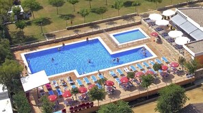 Piscina en la azotea con varias zonas de baño y tumbonas.
