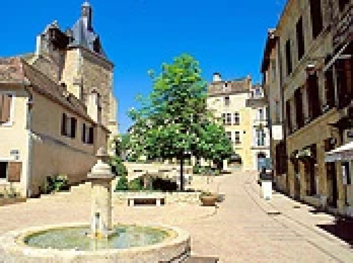 A square with a fountain, surrounded by historic buildings with traditional architecture.
