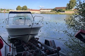 A boat docked at a pier with a water body and buildings in the background. - ZEcamping 3* mobil-home 21m2 4 pers (Auxonne)