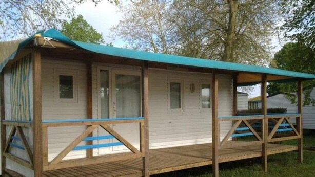 A mobile home with a covered porch and a wooden deck. - ZEcamping 3 étoiles chiens acceptés mobil-home 21m2 4 pers (Auxonne)