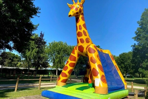 A large inflatable giraffe sculpture in a park.
