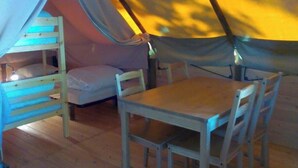 Ein Zelt mit Hochbett, Tisch und Stühlen.