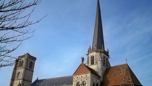 A church with a tall spire and a smaller tower, featuring arched windows and a stone facade. - ZEcamping 3* dog friendly mobil-home 16m2 2 pers (Auxonne)