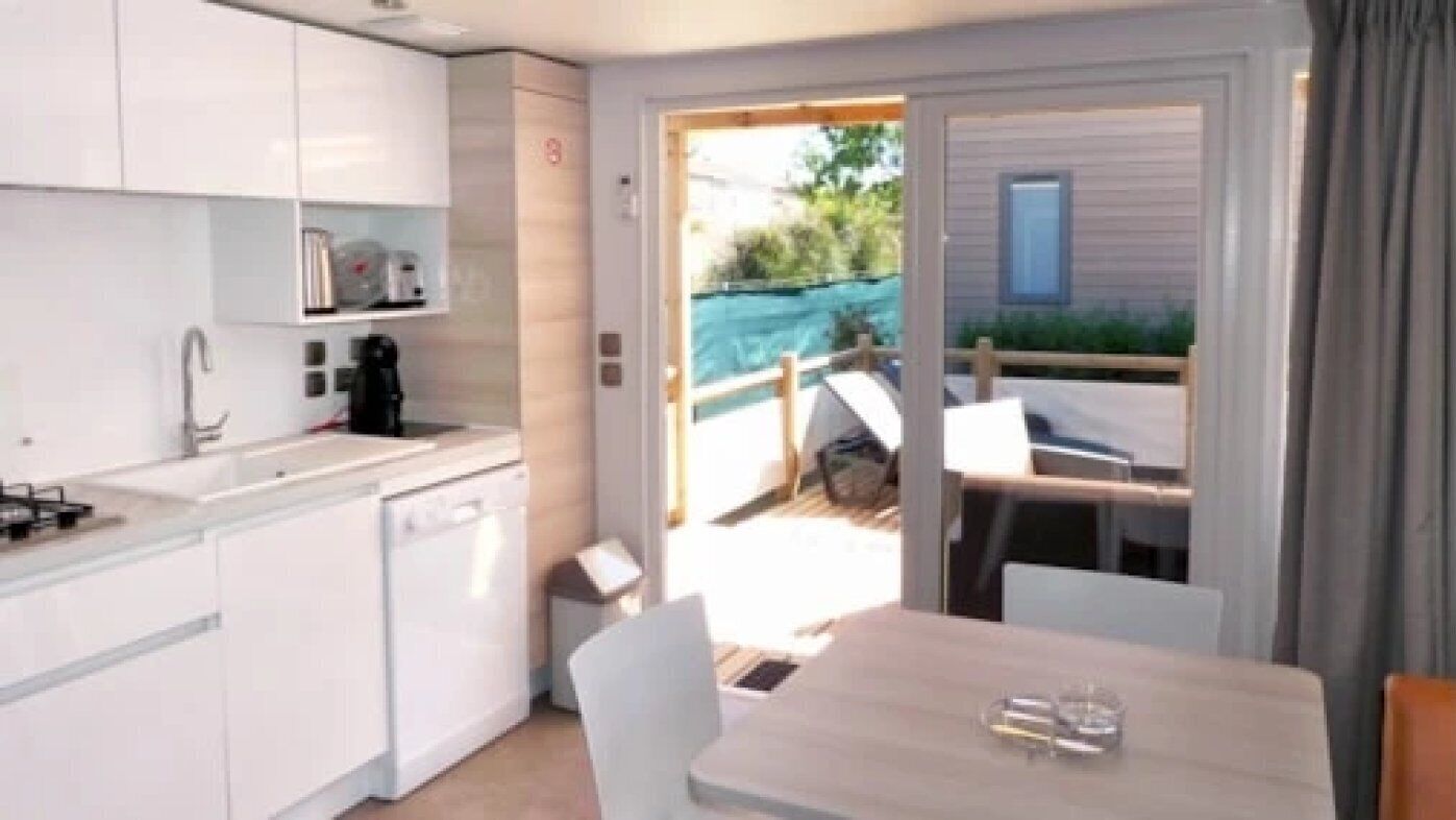 A compact kitchen with white cabinets, a sink, and a small dining area with a table and chairs.