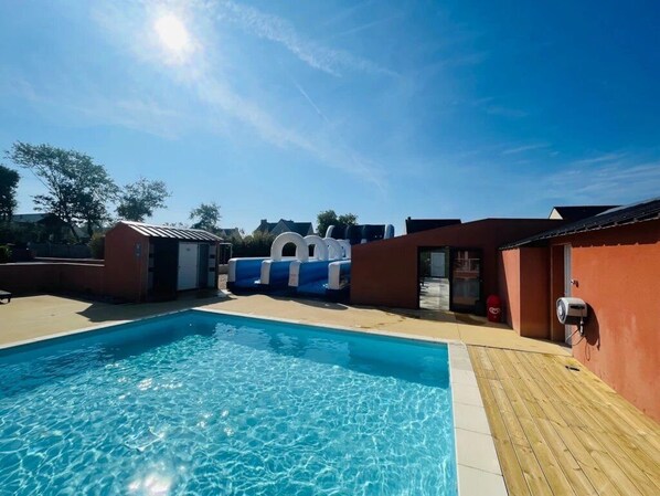 A swimming pool with clear blue water, surrounded by buildings with red and brown exteriors.