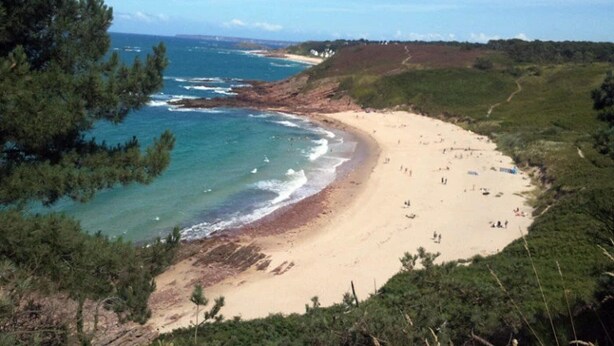 A beach with a sandy shore, surrounded by greenery and a view of the ocean. - ZEcamping 3* piscine couverte animations locatif TV 28m2 4 pers (Erquy)