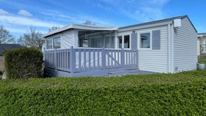 A mobile home with a covered porch and a fenced deck. - ZEcamping 3* animé piscine couverte chiens acceptés locatif TV 30m2 (Erquy)