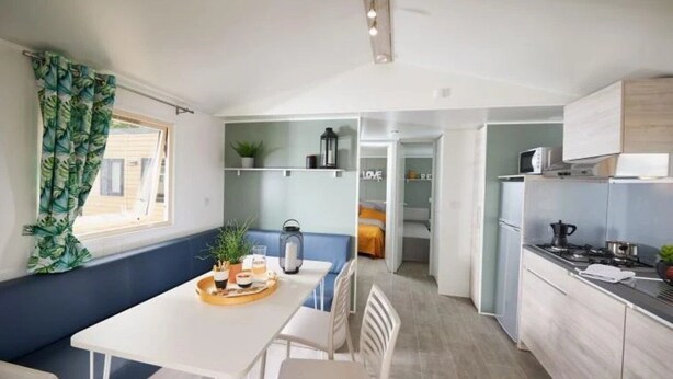 Een compacte keuken met een eethoek, een kitchenette en een klein zithoekje.