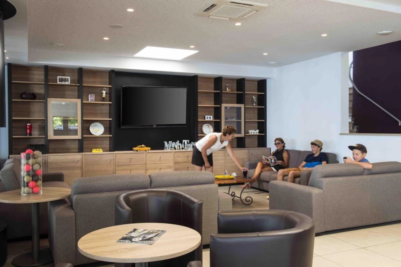 A modern living room with a flat-screen TV, sofas, and a coffee table.