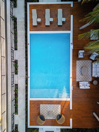 Outdoor pool, sun loungers. The Palms Belize