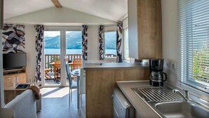 Cocina compacta con lavamanos, cafetera y vistas al exterior.