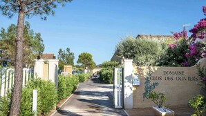 A gated entrance to Domaine Clos Des Oliviers with a clear pathway leading to the property.