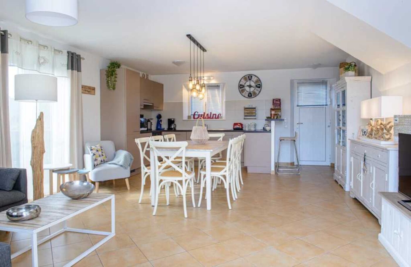 Un saló modern amb zona de menjador, cuina i un petit espai d'oficina.