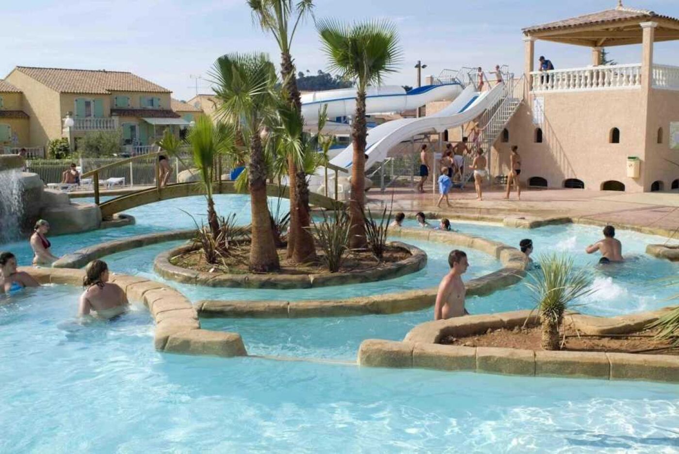 A pool area with multiple water features, including a central water slide and surrounding hot tubs.