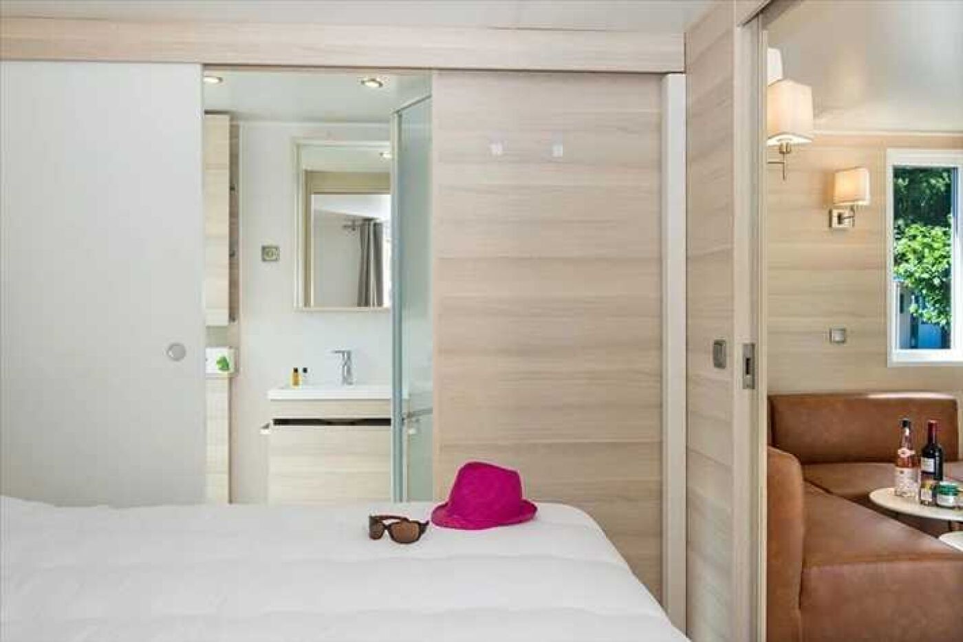 A hotel room with a bed, a bathroom, and a seating area with a table.