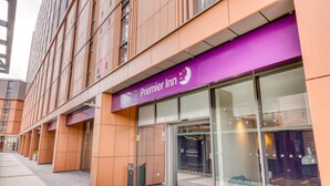 A hotel entrance with a purple awning, a glass door, and a sign welcoming guests. - Premier Inn London Hammersmith - Talgarth Road (London)
