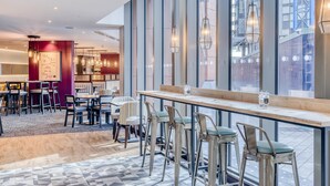A modern hotel lobby with a bar area, seating, and large windows. - Premier Inn London Hammersmith - Talgarth Road (London)