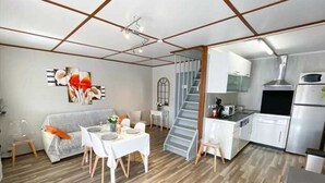Una cocina moderna con armarios blancos y una campana extractora de acero inoxidable.