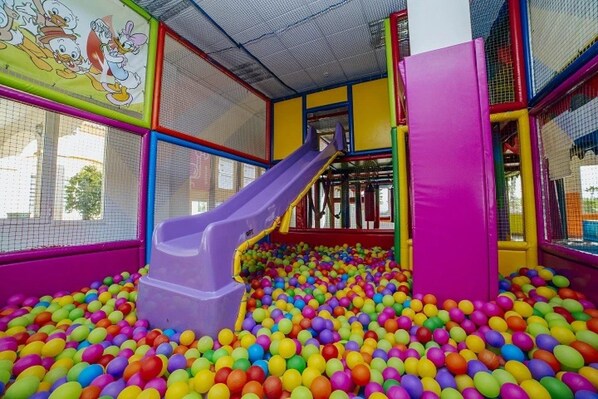 A play area with a slide and a ball pit filled with multicolored balls.