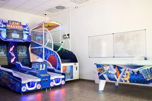 An indoor arcade with various gaming machines, including a 'Lane Master' game, and a table with a 'BIG' game.