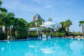 A swimming pool with a water slide structure in the background.