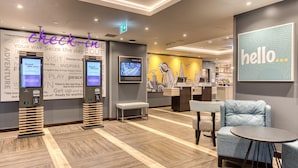 A hotel lobby with check-in kiosks, seating areas, and a bar. - Premier Inn London Waterloo - Lambeth Road (London)