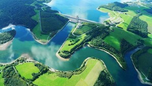 An aerial view of a coastal area with a bridge, green fields, and water bodies. - ZEcamping 4* animé locatif TV LV clim 130m2 8 pers (Froidchapelle)