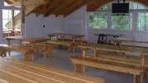 A rustic cabin with wooden benches and a large window. - ZEcamping 2* animations locatif TV 40m2 5 pers (Fucine)