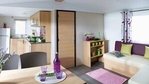 A compact living space with a dining area, kitchenette, and seating area.