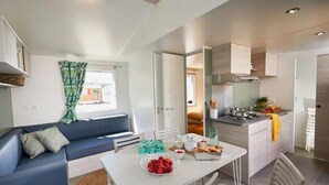 Un espacio habitable compacto con comedor, kitchenette y sofá.