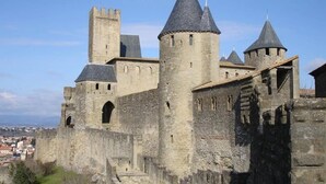 A historic stone castle with multiple towers and a fortified wall. - ZEcamping 3 étoiles pataugeoire piscine chiens acceptés locatif LV (Le Bez)