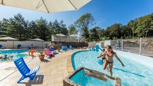 A pool area with clear blue water, lounge chairs, and umbrellas. - ZEcamping 3 étoiles pataugeoire piscine chiens acceptés locatif LV (Le Bez)