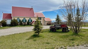 A two-story building with a red roof and a small attached garage. - Quaint lodge wonderful for retreats, reunions, weddings, and relaxation! (Glenwood)