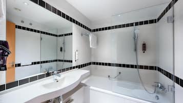 Un baño moderno con un lavamanos blanco, una bañera y una zona de ducha.