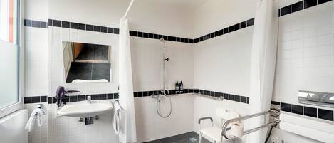 Un baño moderno con lavamanos blanco, inodoro y zona de ducha.