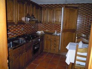 A kitchen with wooden cabinets, a stove, and a tiled backsplash.