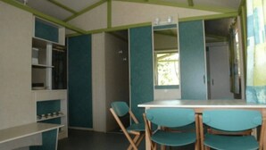 A room with teal and white walls, a white table, and four teal chairs.