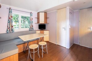 Relax in this cozy space with a bench, TV, and kitchenette access.