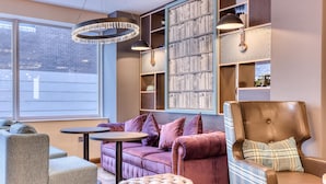 A modern interior with a sofa, armchair, ottoman, and a bookshelf. - Premier Inn Cork City Centre (Cork)