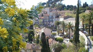 A hillside residential area with terraced houses, palm trees, and a curved pathway. - ZEcamping 3* parc aquatique pet friendly hammam tente clim 33m2 6 pers (Bormes-les-Mimosas)