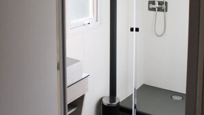 A small, modern bathroom with a glass door, a shower, and a toilet. - ZEcamping 3* parc aquatique pet friendly hammam tente clim 33m2 6 pers (Bormes-les-Mimosas)