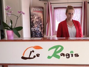A reception desk with a sign reading "Le Rigis".