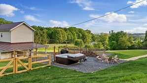 Un jardin avec un jacuzzi, un espace salon extérieur et une terrasse en bois.